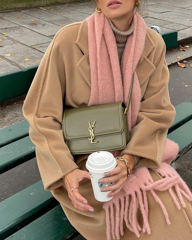 woman in brown cardigan holding a coffee cup while carrying a smooth leather YSL replica, YSL dupe